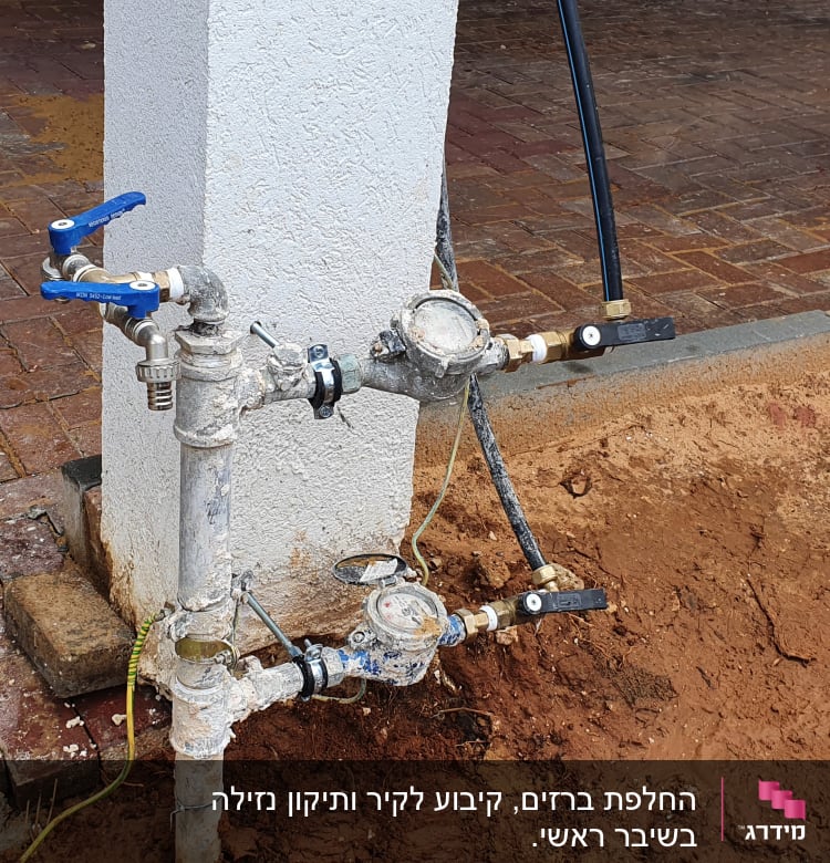 צנרת מים עם ברזים ומדי מים על עמוד